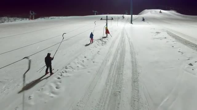 Aerial skiers and snowboarders go up the lift on the slope