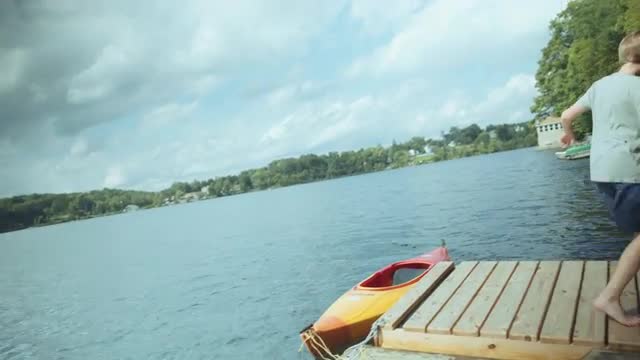 Caucasian boy spinning on floating dock at river