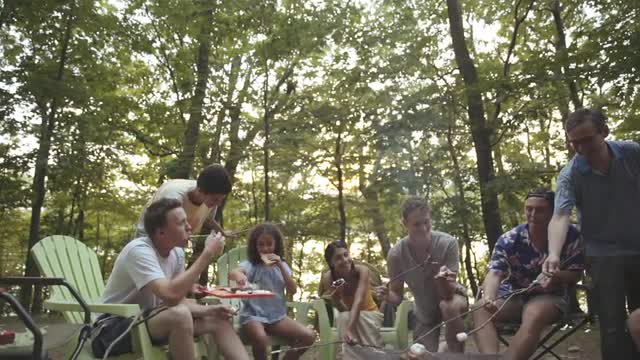 Friends roasting marshmallows in campfire