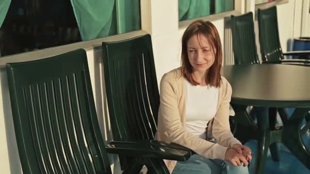 Woman sitting on deck of cruise ship