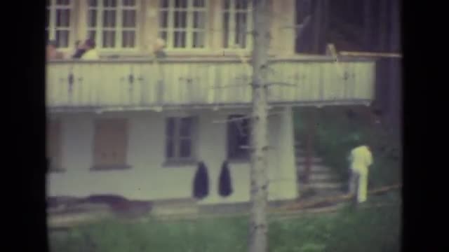 1962: two storied building amid woods with some people in balcony LUCERNE SWITZERLAND