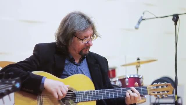 Man in Glasses Plays on Yellow Acoustic Guitar