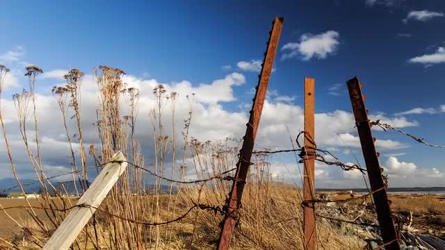 Time-lapse Rusty Fence Post and Clouds with Motion