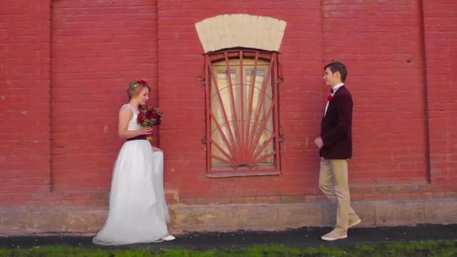 Bride and Groom Met in Street Near Brick Wall