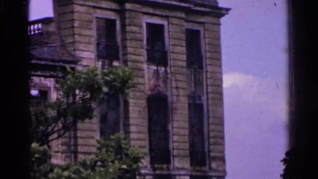 1961: tall brown-brick building with statues on it's top. SWITZERLAND
