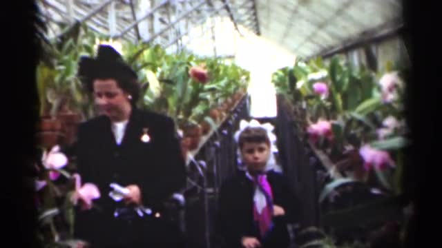 1949: a young woman her daughter are standing in between plants and flowers NEW ORLEANS LOUSIANA
