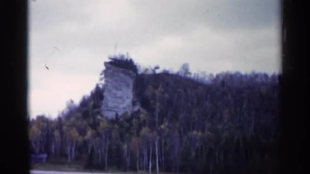 1960: tall cylindrical structure extends in front of round mountain MICHIGAN