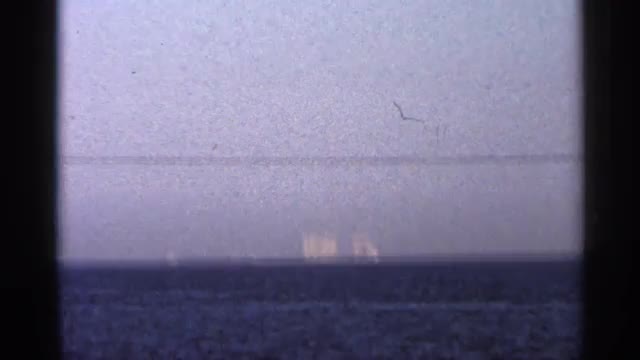 1966: a view of ocean at evening time with small tides on it and with apartments at other side FLORI