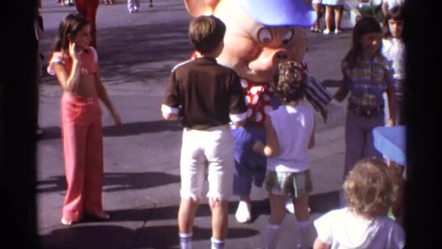 1974: milling people, accosting costumed individual, on sunny day. ORLANDO FLORIDA 1974: milling people, accosting costumed individual, on sunny day. ORLANDO FLORIDA