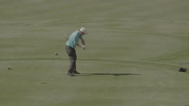 Medium shot revealing golfer hitting tee shot