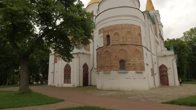 Camera Approaches to Cathedral Tower Monument Statue on Courtyard White Walls Are Partly Brown Brick