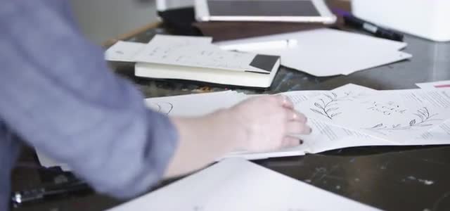 Worker shuffling through papers at work.