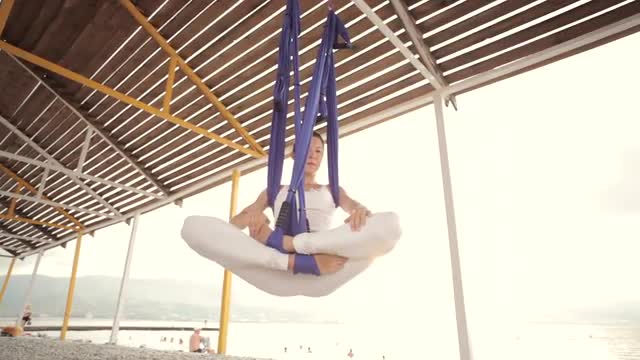 Anti-gravity Yoga, woman doing yoga exercises