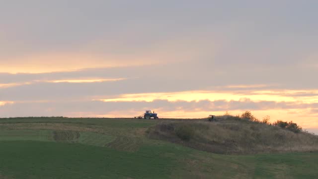 Two Tractors on Background of Sunset Open Space Beautiful Evening Landscape Field Steppe in Ukraine 
