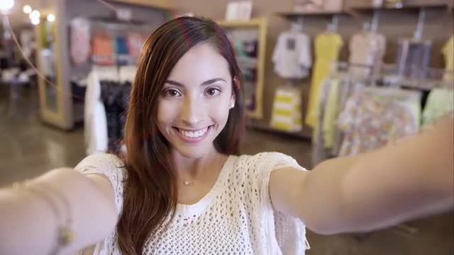 Attractive woman holding camera shooting selfie