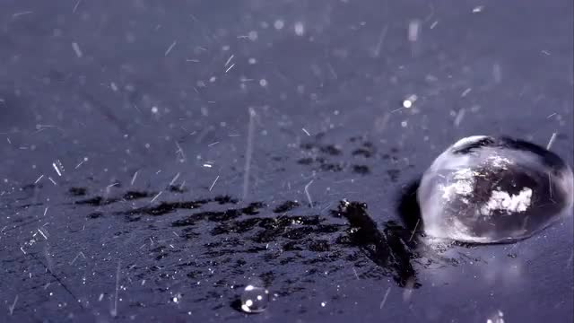 Water drop falling on hot plate and sizzling.