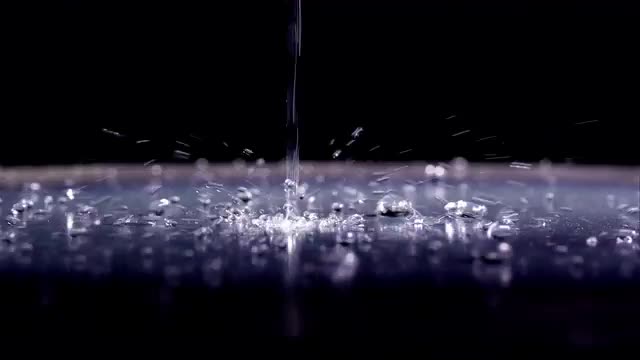 Water droplets bouncing on shinny surface.
