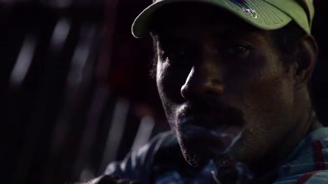 Man looks at camera while smoking cigarette, high speed closeup