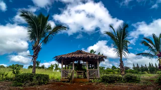 Moving clouds above old Hawaiian hut