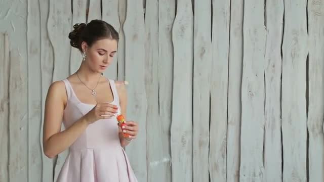 2 shots. Sensual woman with make-up and elegant hairstyle blowing bubbles 2 shots. Sensual woman with make-up and elegant hairstyle blowing bubbles