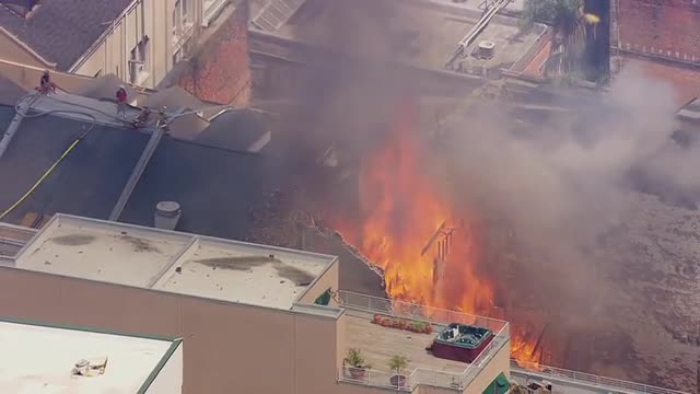 MS POV AERIAL ZO Firefighter pouring water from hose to bring fire under control / United States