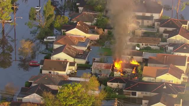 MS POV AERIAL ZI Smoke arising due to house on fire in flooded area / United States