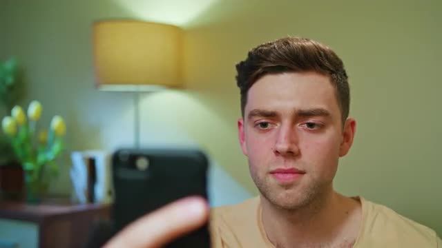 Disappointed Man Drinking and Using Cellphone