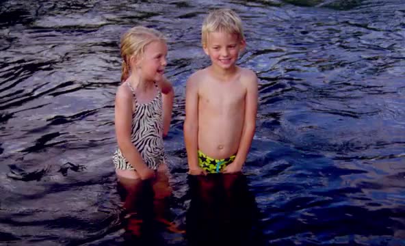 children in bathing suits standing in water