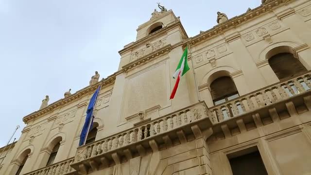 Italian and European flags on the historic building of Town Hall of Padua
