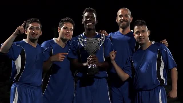 A soccer team proudly holding a trophy