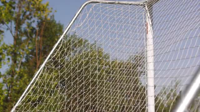 Close up of a soccer ball hitting a net