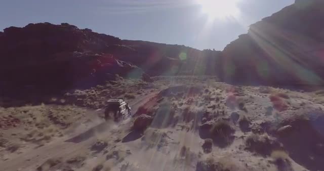 An aerial shot of an off road vehicle driving through Lathrop Canyon Road Canyonlands National Park.