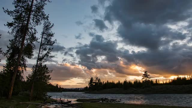 Time lapse after the sun has set over forest along river in Yellowstone