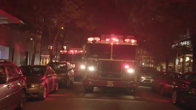 fire truck with flashing siren lights standing in the city at night