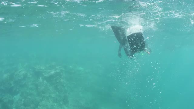 Diver Kicks Bubbles Towards Cam
