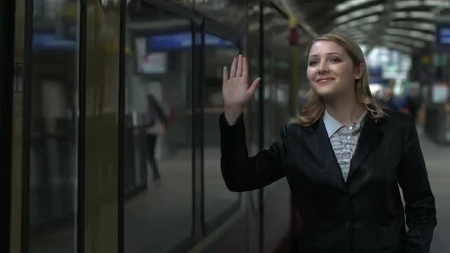 saying goodbye women waving hand in strain station