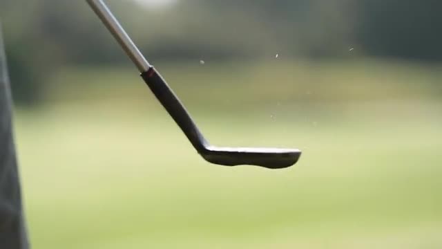 Golfer bouncing golf ball with wedge