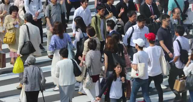 Pedestrians walking on zebra crossing downtown Tokyo, Japan