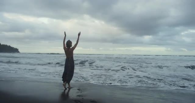 Woman Lifts Arms To the Ocean