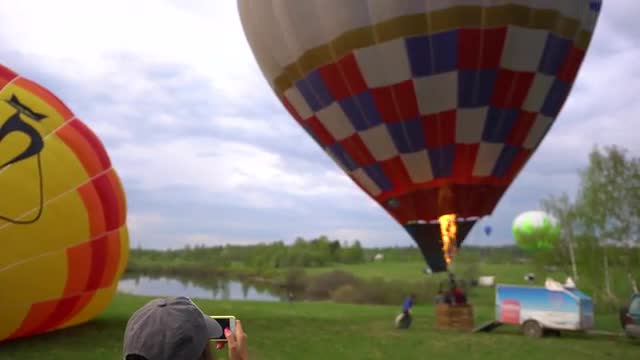 MOSCOW, RUSSIA - JUNE, 15 2017: Woman makes photo of inflating hot air balloon named Aerowalz. Handh