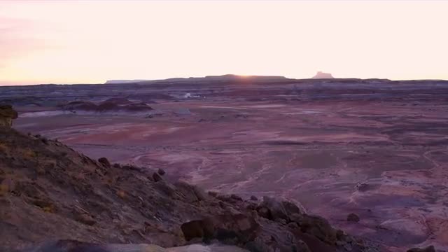 Flying towards sunset past rock formation towards Mars research station