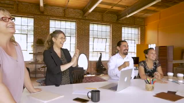 Diverse group of creative business team members celebrating with high fives