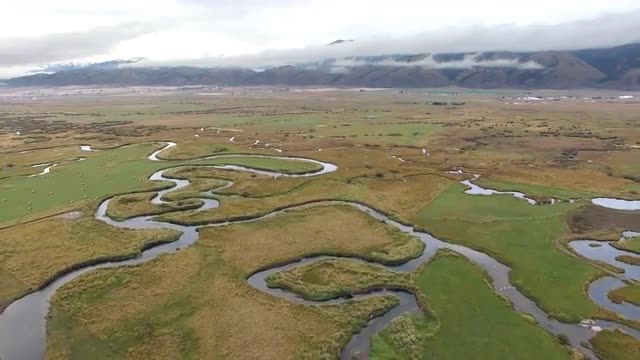Salt River winding through pastures with Salt River Mountain Range