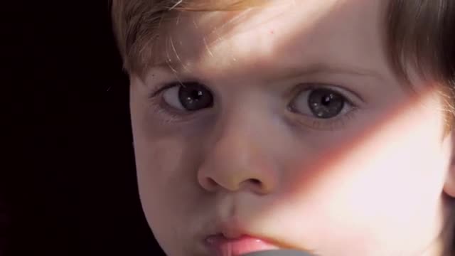 Little blond boy looking at camera extreme close up