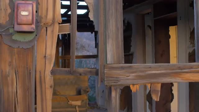 Abandoned dilapidated wood house with old furniture and broken wall with dolly