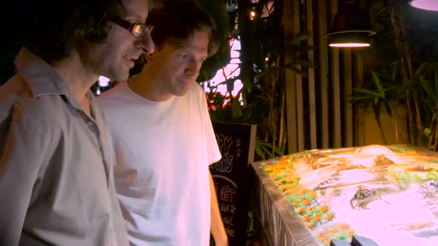 Two young men look at fresh fish in a restaurant together