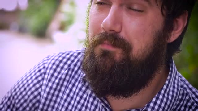 Dolly shot of a portrait of a bearded man severely depressed and crying