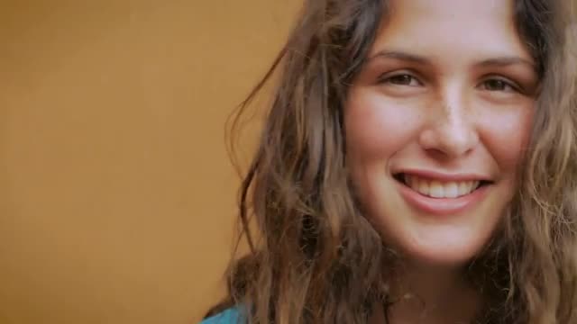 Close up portrait of a young woman with long hair smiling for the camera