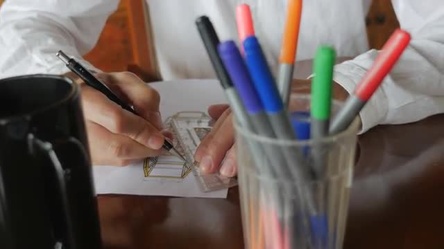 Handheld of Engineer designing by hand with pencil and paper at desk
