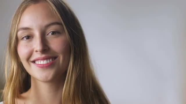 A beautiful young woman with long blond healthy hair in slow mo
